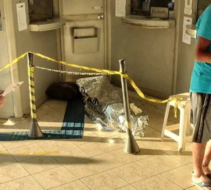 Assustador: lotérica atende clientes ao lado de homem morto no local